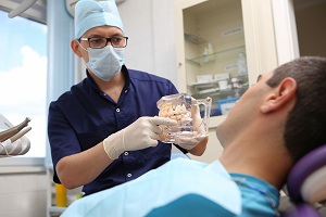 Лечение каналов Врач поясняет пациенту методику лечения каналов